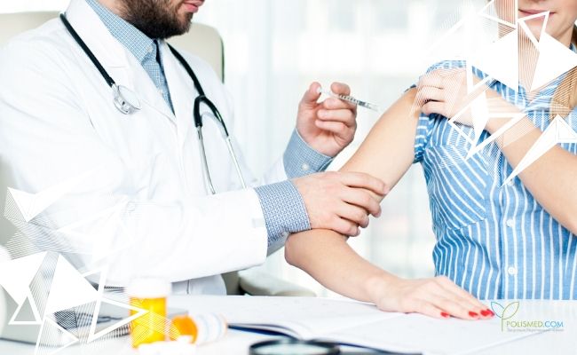 Женщине делают укол в плечо